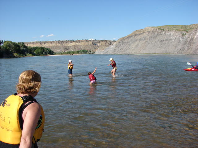 We wade out away from the raft and toward the rapids.