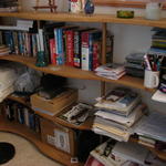 Bookshelf made my Larry Lynam.  Books, DVDs, external drive, cameras, small purple vase from Malta (C & C) and 2 little pott