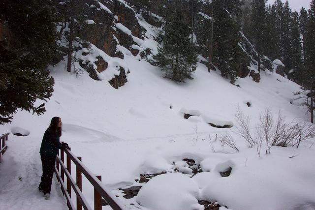 Mal pauses at the bridge to watch the snow fall and view the scenery.